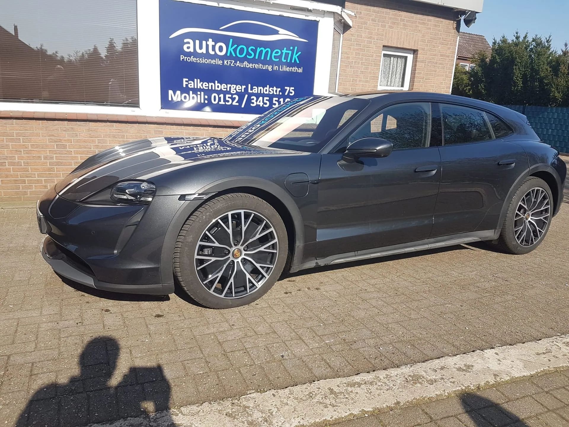 Dunkler Porsche Taycan vor dem Aufbereitungsstudio in Lilienthal